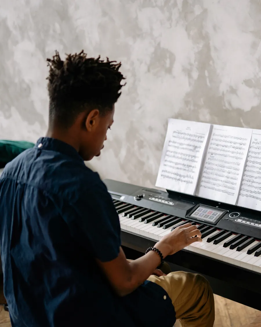 Aluno estudando piano com partitura